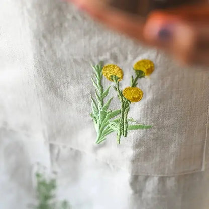 Tablier brodé à motifs botaniques